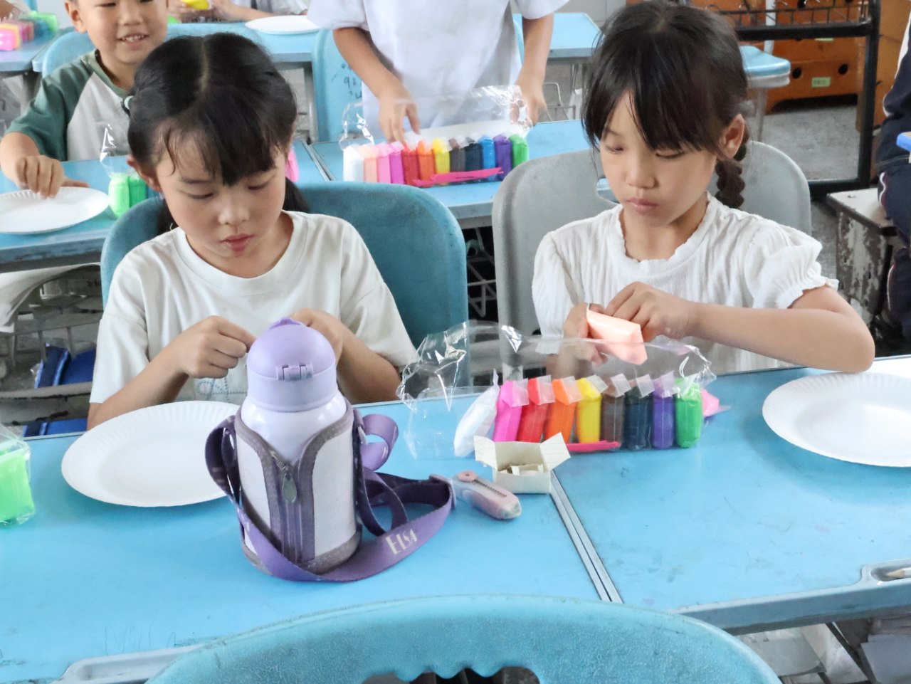 孩子们在蓝色课桌上制作粘土作品